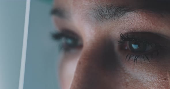 A caucasian woman is viewed closeup in the workplace, wearing protective face screen over her eyes