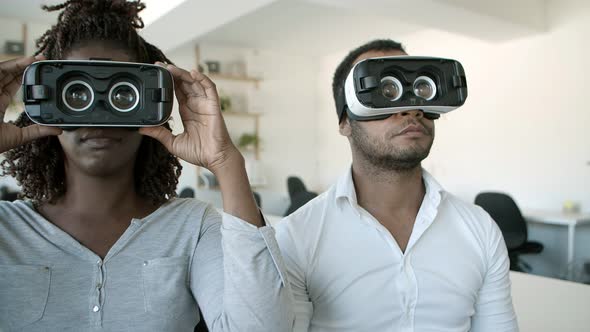 Focused African American Testers Wearing VR Glasses at Office