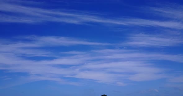 Beautiful fly over abstract shot of a sandy white paradise beach and blue ocean background in colorf