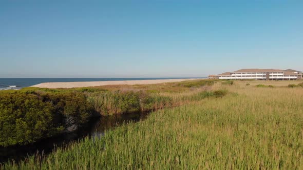 Low flying drone shot of sand dunes, marsh and creeks in Oak Island NC shot in 4k