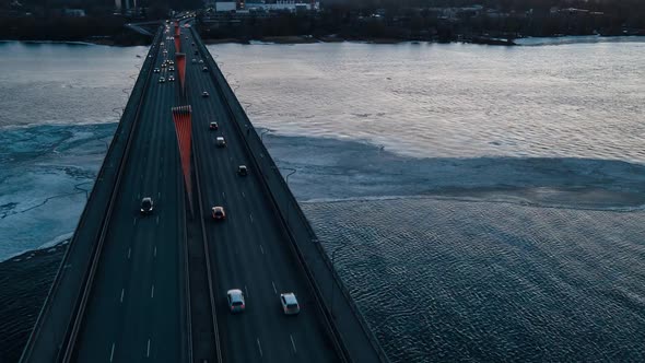Beautiful Aerial Hyperlapse Over Busy Bridge with Fast Moving Cars and River with Waves Made By Wind