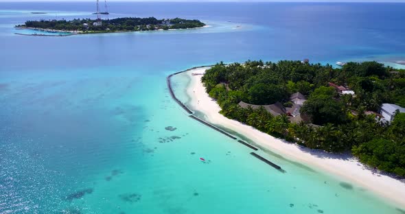 Natural fly over travel shot of a white sandy paradise beach and aqua blue water background 