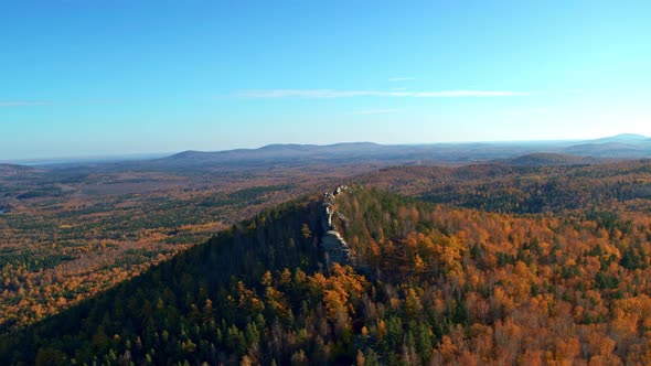 A Rock with an Autumn Forest on the Slopes