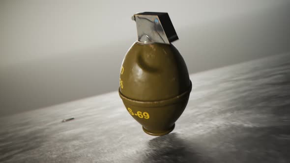 Threw lemon M26 hand grenade rotating on concrete floor with safety pin. 4k HD