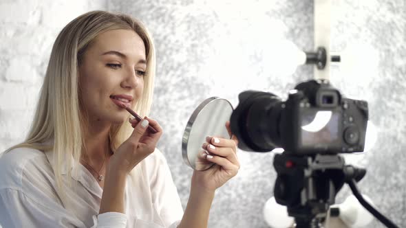 A Pretty Makeup Artist Is Applying Lipliner on Her Lips Looking in a Mirror