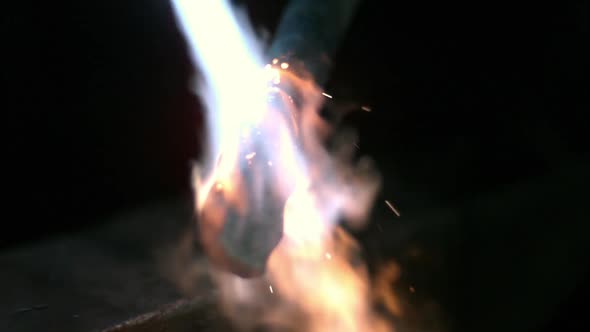 Slow motion of torch heating up piece of metal.