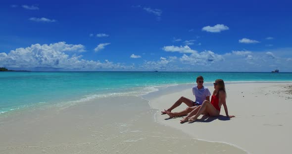 Beautiful boy and girl on romantic honeymoon enjoy luxury on beach on paradise white sand background