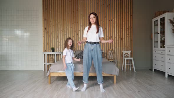 Brunette Mother Teaches Daughter New Dancing Moves in Room