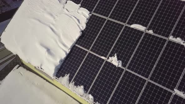 Closeup surface on a house roof covered with solar panels in winter with snow on top.