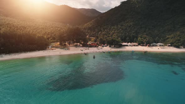 Aerial Blue Lagoon on Beach Hotel Palms Mountains Trees Slow Motion