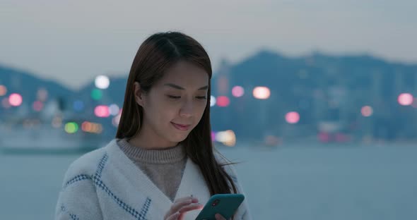 Woman use of mobile phone in city at night