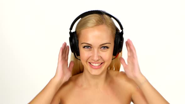 Beautiful Female in Headphones Listening To the Music with Fluttering on the Wind Hair Over White