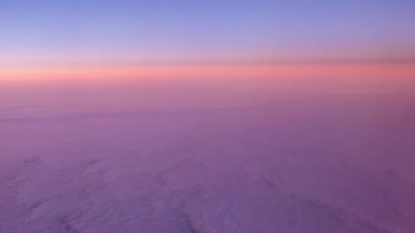 Flight above clouds at sunrise