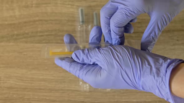 Nurse's Hands Preparing a Syringe for Injection or Vaccination