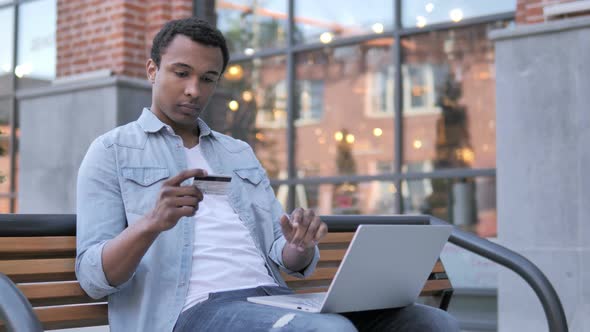 Successful Online Shopping by African Man Sitting on Bench