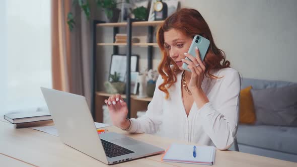 Successful Caucasian Woman Works on Computer and Speaks on Phone at Same Time