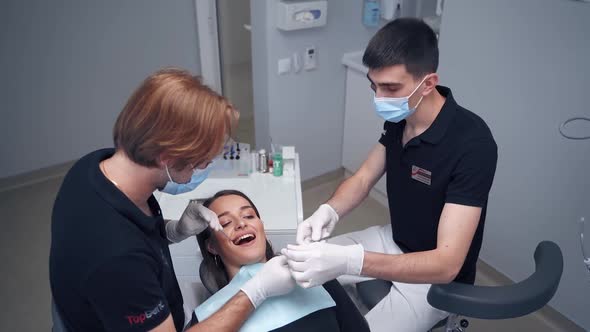 Dentist examining woman. Beautiful smiling woman with healthy straight white teeth sitting at dental