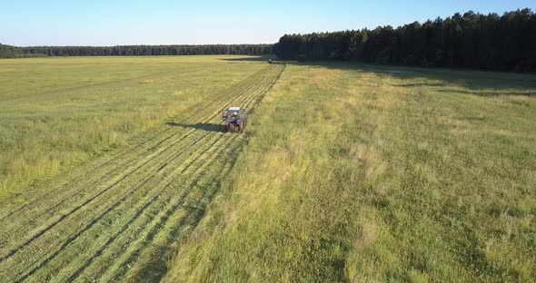 Mowing Machine Drives Cutting Off Grass on Farmland