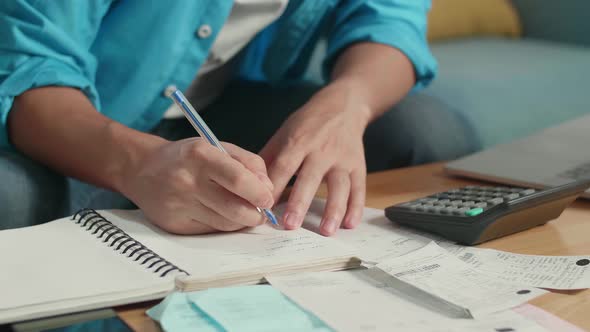 Close Up Of Man's Hand Recording The Expenses In Notebook