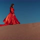An Asian Woman in a Red Dress Dancing on Sand Dunes - VideoHive Item for Sale