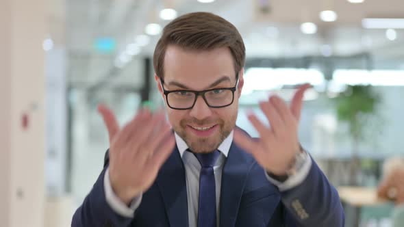 Portrait of Cheerful Businessman Pointing and Inviting 