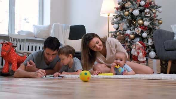 Family of Four Spending Time Beside Xmas Tree