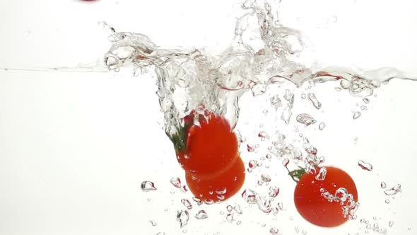 Whole Tomatoes Falling Through Water