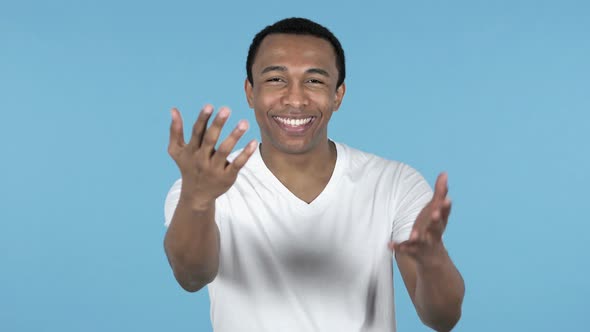 African Man Inviting Customers with Both Hands, Blue Background