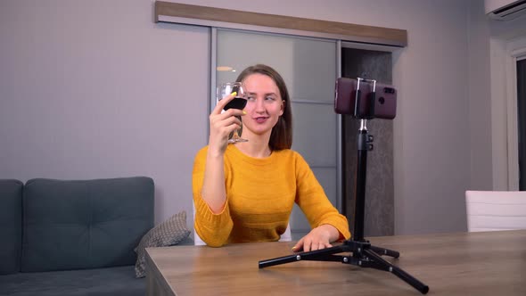 girl blogger tells her impressions about taste of wine on mobile phone camera.