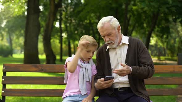 Boy Teaching Grandpa to Use Smartphone, New Technologies Difficult for Pensioner