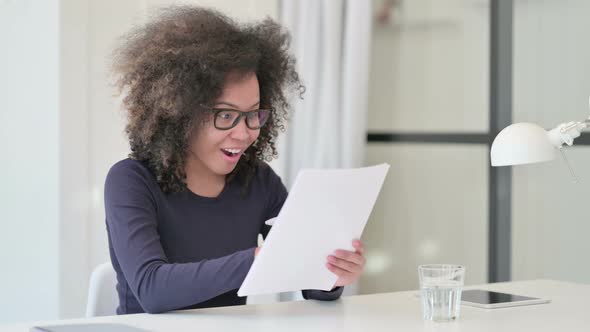 Successful African Woman Excited While Reading Documents