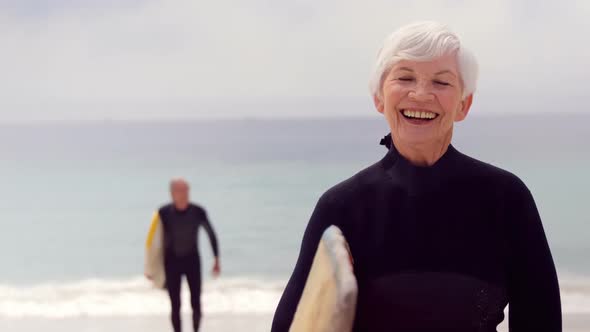 Retired Couple Holding Surfboards