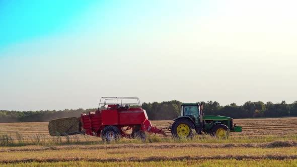 Haymaking tractor on field. Agriculture machine harvesting hay in fields