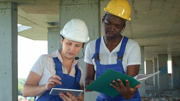 Workers working on building site with tablet