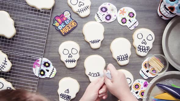 Step by step. Flat lay. Decorating sugar skull cookies with different color royal icing.