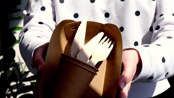 Slow Motion Female Hands Holding Wooden Forks and Paper Cups with Plates