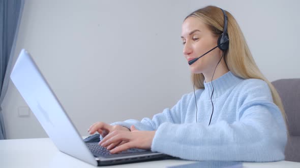 Cheerful helpdesk operator woman wearing headset and speaking on web camera in 4k video