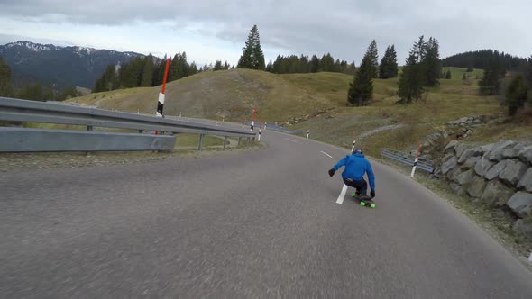 A skateboarder downhill skateboarding on a mountain highway road
