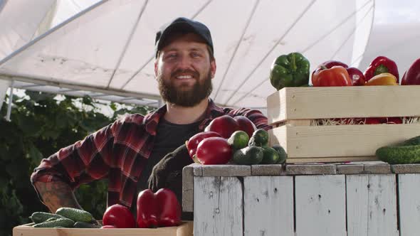 Optimistic Adult Gardener Standing Near Vegetables