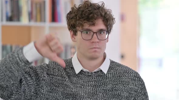 Portrait of Upset Young Man with Thumbs Down