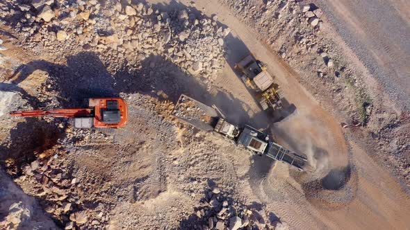 The Excavators Loading of a Stone in the Dump Trucks