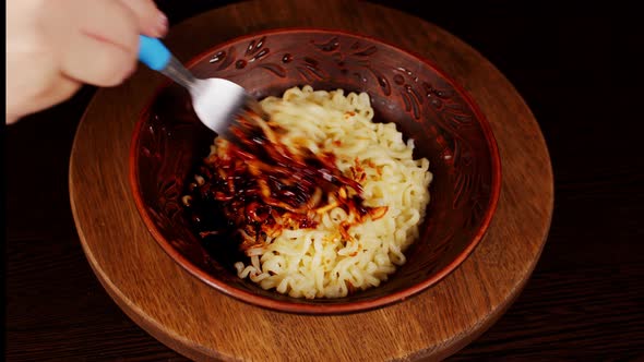 Readymade Instant Noodles with Condiment and Spicy Sauce in Plate on Wooden Board