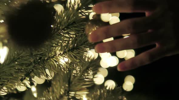 Female Touching Christmas Ball On Tree