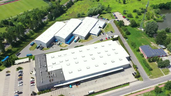 Moving Aerial Side Shot of Industrial Warehouse Loading Dock where Many Truck with Semi Trailers Loa