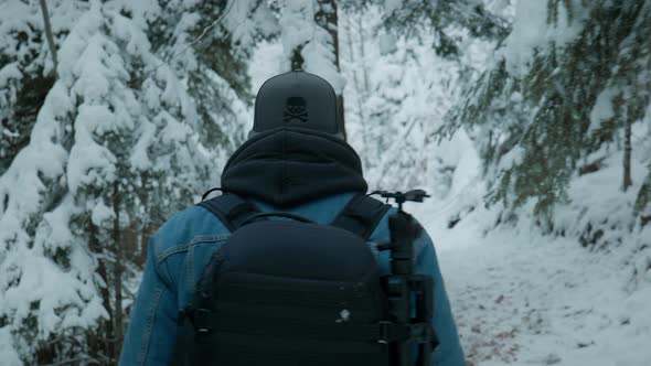 Photographer with a camera walking through the snowy forest