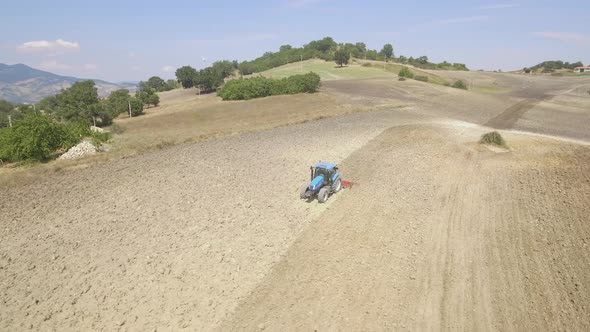 Farmer on tractor plowing a field in Umbria, Italy