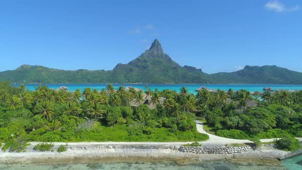 Aerial drone view of a luxury resort and overwater bungalows in Bora Bora tropical island.