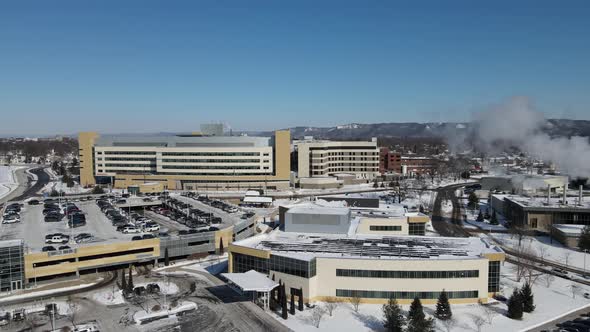 Beautiful sunny day overlooking large building complex with snow covered mountains.