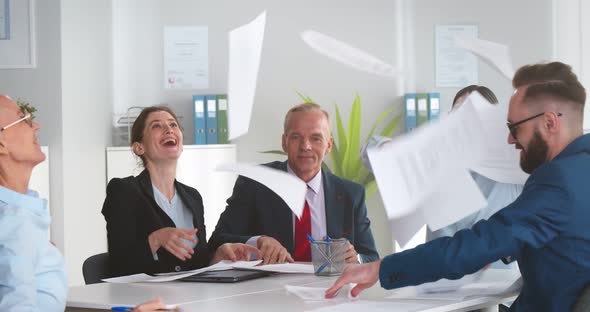 Diverse Business Team Throwing Papers in Air Celebrating Successful Financial End of Year