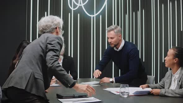 Elderly Man and Young Man Shake Hands Greeting at Business Meeting